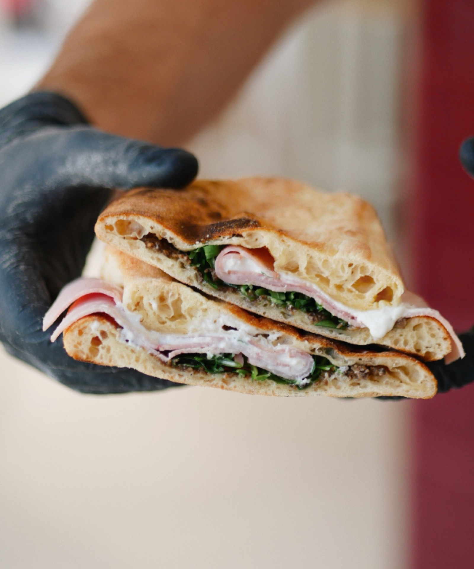 Panuozzo coupé en deux, jambon, mozzarella et roquette